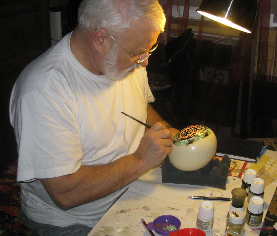 Joël Vilain en train de peindre sur un oeuf d'autruche